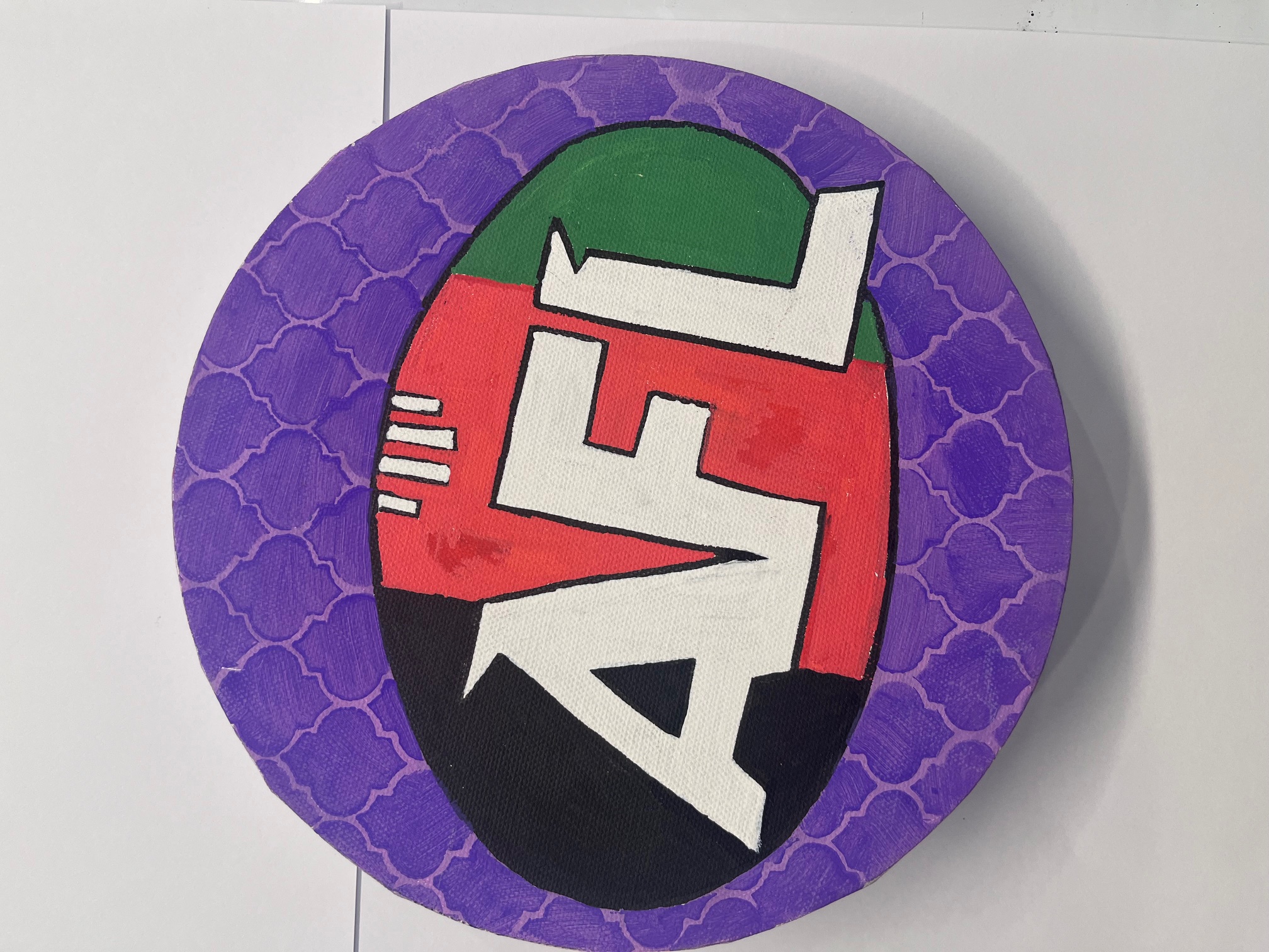 Round canvas with the AFL logo in red, green and black on a purple Moroccan-patterned background